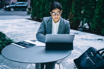 Businesswoman working at tablet in outdoors cafe
